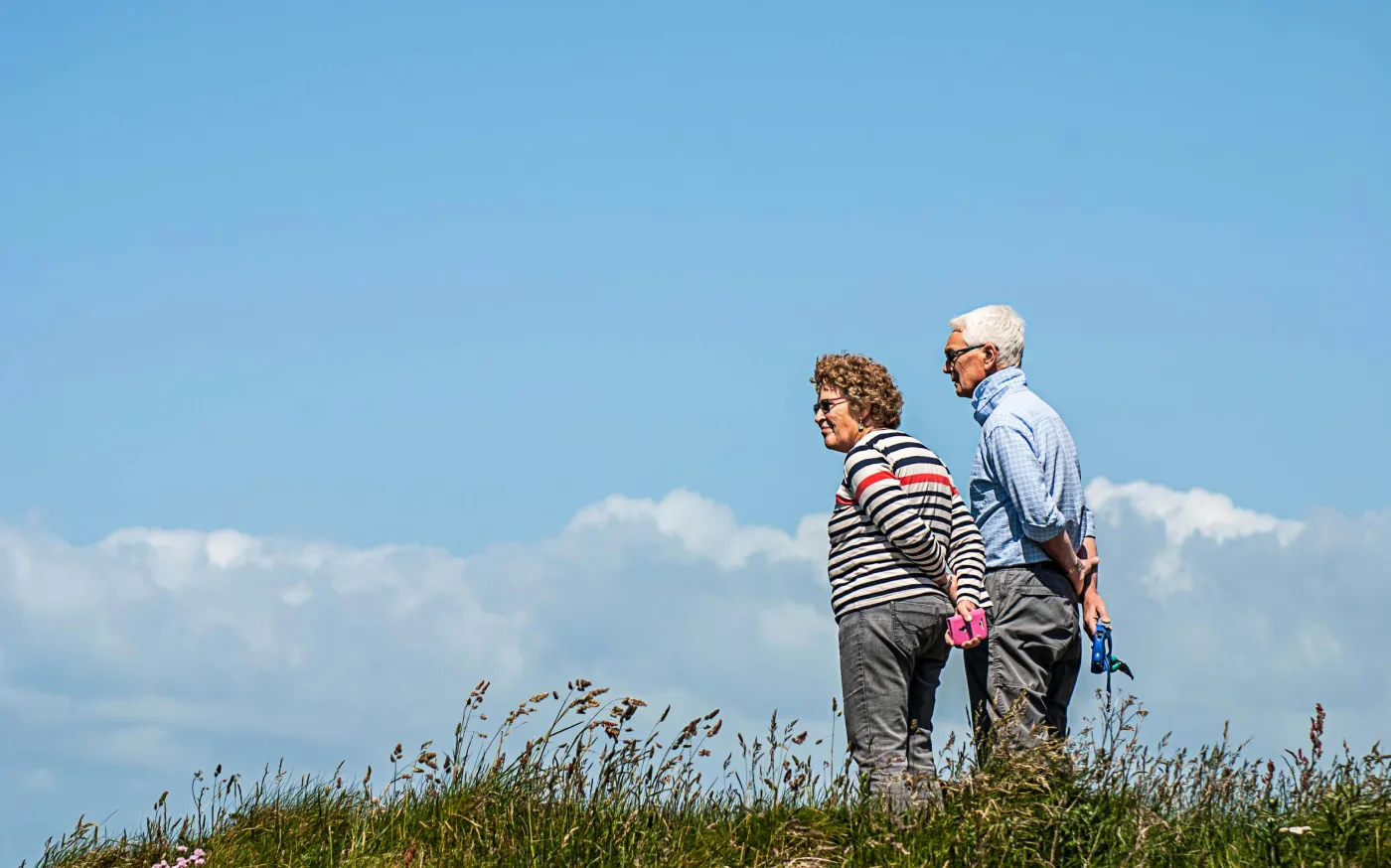 man in white dress shirt and black pants standing beside woman in black and white striped by Monika Kubala courtesy of Unsplash.