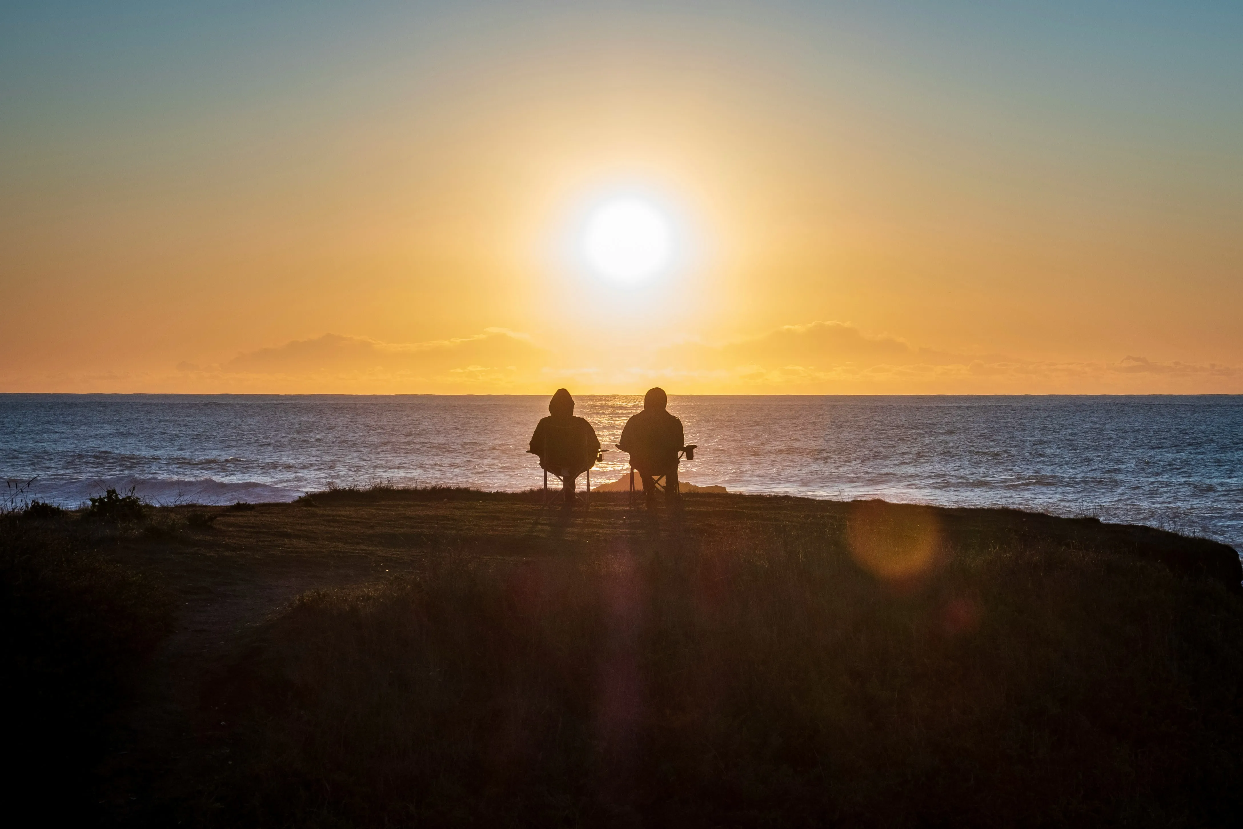 two people sitting on seashore by Anukrati Omar courtesy of Unsplash.