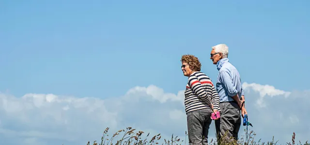 man in white dress shirt and black pants standing beside woman in black and white striped by Monika Kubala courtesy of Unsplash.